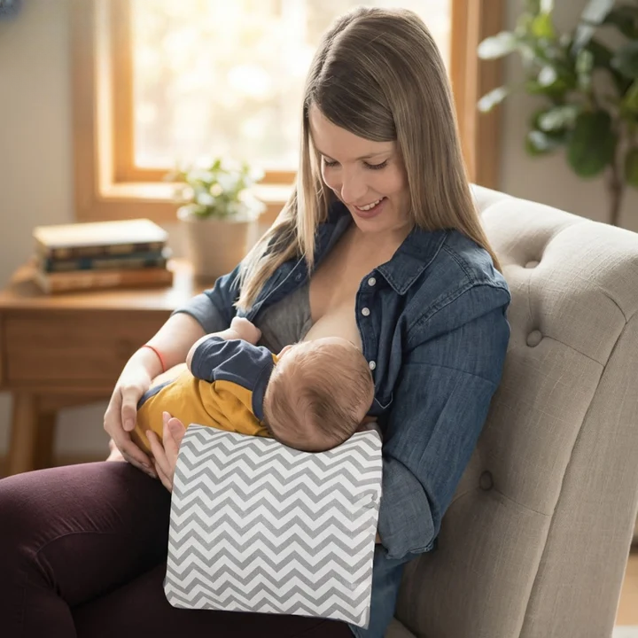 Woman breastfeeding baby with gray chevron Arm-Stillkissen nursing pillow on armchair