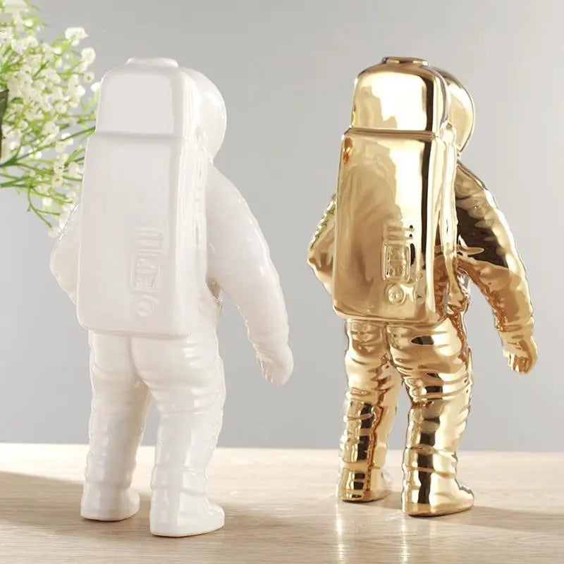 Back view of white and gold astronauten-figur planters near window