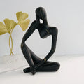 Abstrakte Denker Skulptur in black marble finish displaying contemplative seated pose