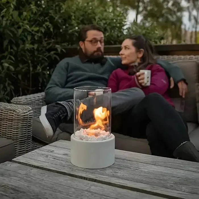Tragbare Tischfeuer-Laterne on table with couple relaxing outdoors